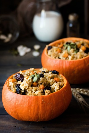 Traditional Russian millet porridge with raisins and pumpkin stewed in the oven. Pumpkin serving instead of platesの写真素材