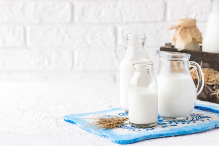 Bottles of milk of various shapes and sizes on a light backgroundの写真素材