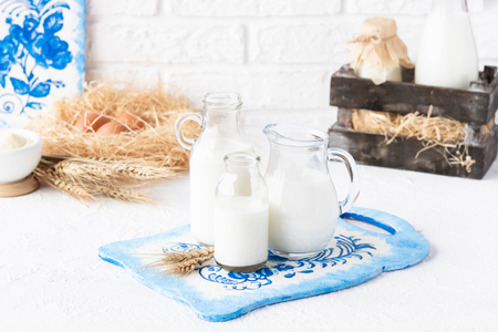 Bottles of milk of various shapes and sizes on a light backgroundの写真素材