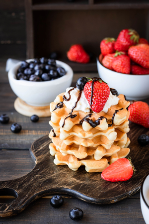 Viennese waffles with whipped cream and fresh berries as a summer breakfast conceptの写真素材