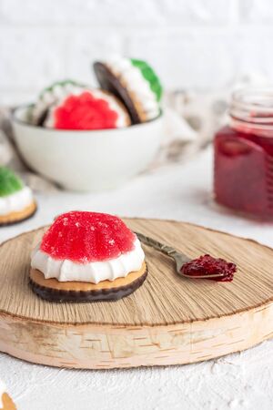 Chocolate-covered biscuits with marshmallow layer and marmalade hat on a light backgroundの写真素材