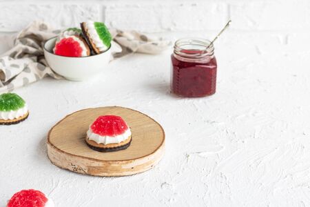 Chocolate-covered biscuits with marshmallow layer and marmalade hat on a light backgroundの写真素材