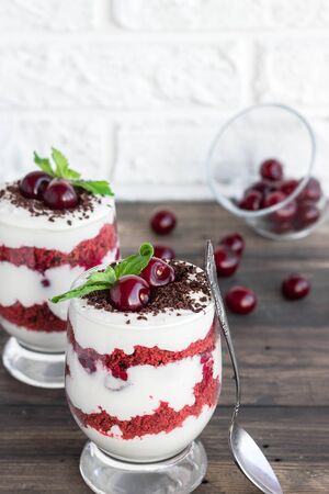 Light berry dessert. Trifle red velvet with cherry and cream cheeseの写真素材