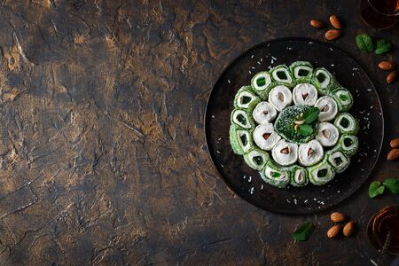 Turkish Delight. Assorted multi-colored oriental sweets with almonds on a round tray on a dark background.の写真素材