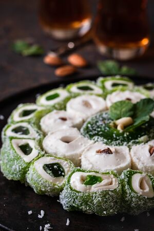 Turkish Delight. Assorted multi-colored oriental sweets with almonds on a round tray on a dark background.の写真素材