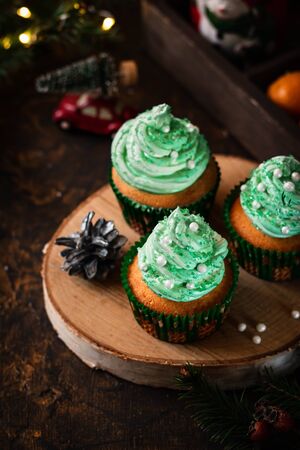Mandarin cupcakes with festively decorated caps from butter cream. New Year and Christmas dessert.の写真素材