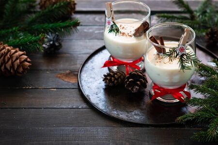 A traditional eggnog Christmas drink in a glass goblet decorated with New Year clothespin. Non-alcoholic option. Atmospheric photos.の写真素材