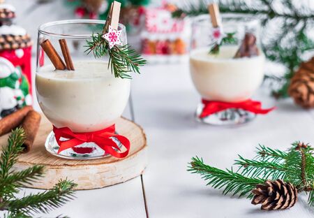 A traditional eggnog Christmas drink in a glass goblet decorated with New Year clothespin. Non-alcoholic option. Atmospheric photos.の写真素材