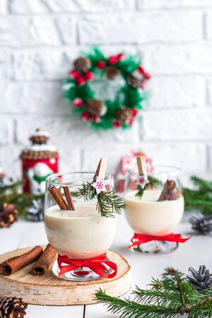 A traditional eggnog Christmas drink in a glass goblet decorated with New Year clothespin. Non-alcoholic option. Atmospheric photos.の写真素材