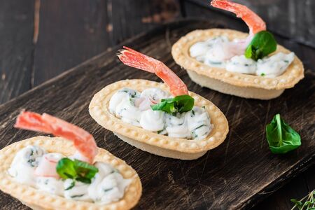 Tartlets with spicy curd cheese and shrimp. Simple and easy snack. Beautiful and comfortable food.の写真素材