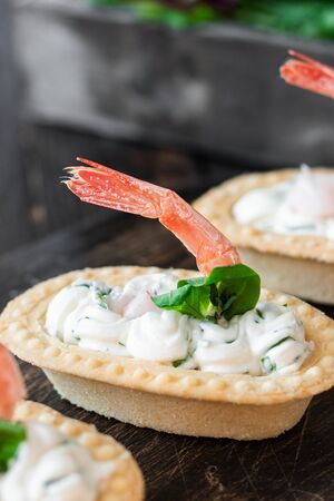 Tartlets with spicy curd cheese and shrimp. Simple and easy snack. Beautiful and comfortable food.の写真素材