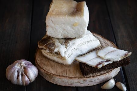 Two large pieces of salted pork lard salted pork lard with garlic on a dark wooden background. Rustic style.の写真素材