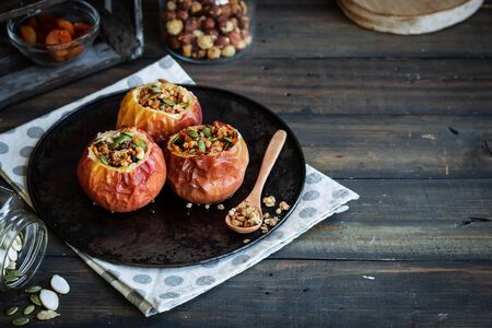 Baked apples with nut granola and pumpkin seeds. A wholesome and simple dessertの写真素材