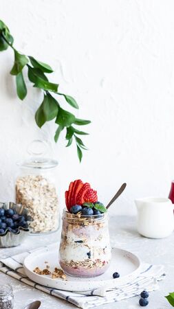 Yogurt pudding with chia seeds, homemade granola and fresh berries in a glass jar. Light snack. Healthy breakfast option.の写真素材