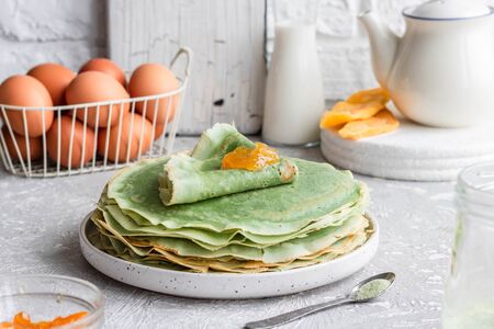 Green pancakes with matcha tea and mango jam. Fancy pancakes. Pancakes on a Shrovetideの写真素材