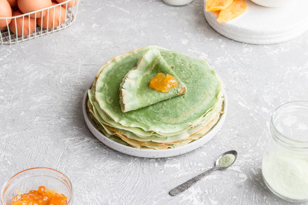 Green pancakes with matcha tea and mango jam. Fancy pancakes. Pancakes on a Shrovetide