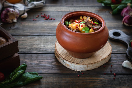 Roast in a clay pot in a rustic style. Braised beef with vegetables. Georgian dish of Canahi