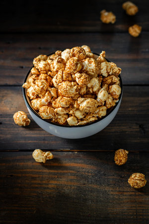 Salted caramel popcorn in a white plate. Dark wood backgroundの写真素材