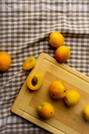 Apricots lying on a wooden board, freshness, harvesting, autumn mood, beautiful decoration with a kitchen towelの写真素材