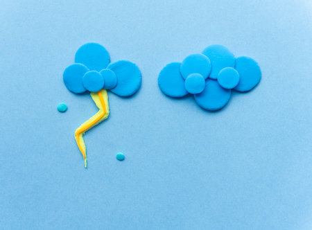 cloud with lightning from plasticine on blue backgroundの写真素材