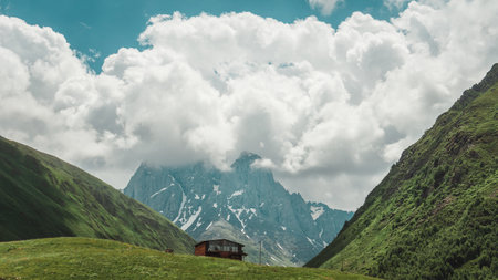 Picturesque rocks and mountains, a beautiful lonely house stands against the background of the mountains. Amazing landscape of nature and skyの写真素材