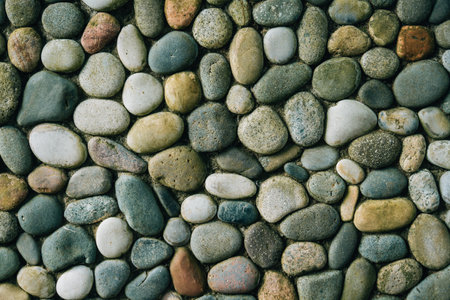a wall of round stones, smooth neat stones from the shore, bouldersの写真素材