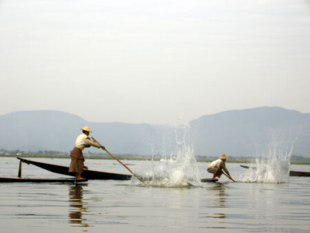 Men slapping water to attract fishのeditorial素材