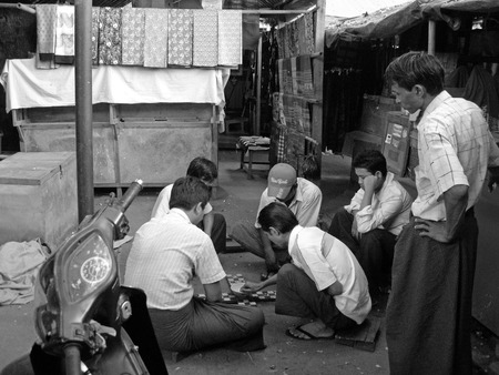 men gambling in an alley in the market in Myanmarのeditorial素材