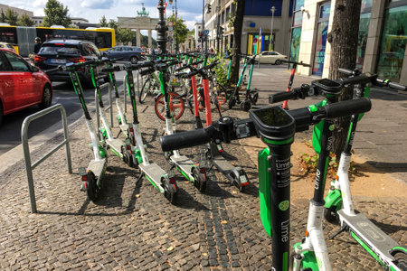 BERLIN - SEPTEMBER 08, 2019: Many Electric E-Scooters of different Ride Sharing Companies parked chaoticly on a sidewalk in Berlin close to the Brandenberg Gate. Modern and trendy City Transportのeditorial素材