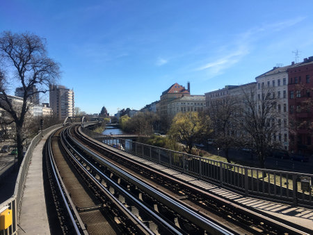 Metro Train (U-Bahn) Tracks going through Berlin next to Landwehrkanal and Houses in sunny spring weather with blue sky. Berlin Public Transportation is one of the best in Europe and Eco-friendly.のeditorial素材