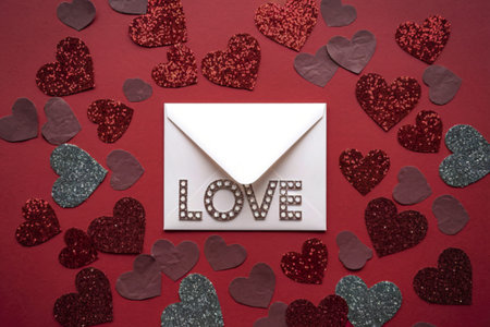 A photo of a vibrant red background with various glittery, heart-shaped cutouts