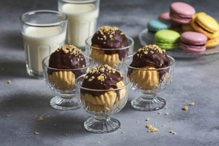 A photo of a platter of chocolate-covered profiteroles garnished with crushed nuts