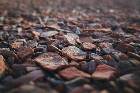A photo of a textured ground surface made of crushed red and brown stones
