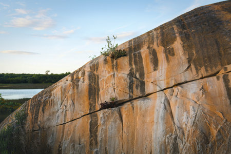 a large rock with a texture of orange and beige hues