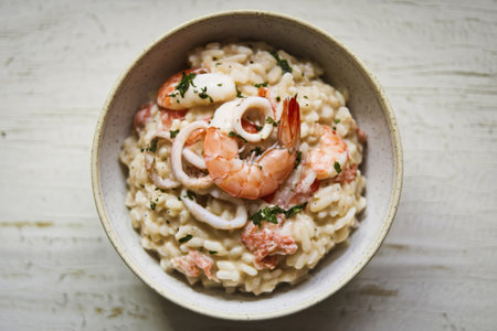A photo of a bowl of seafood risotto placed on a white surface.の写真素材