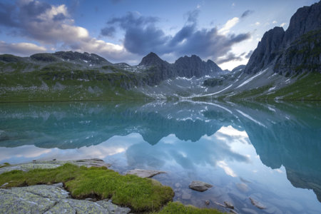 A photograph of a pristine turquoise lake cradled between colossal, snow-capped mountains
