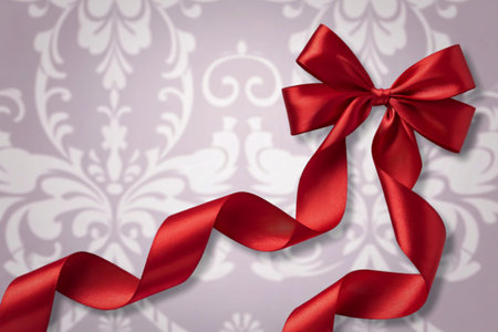 A photograph of a vibrant red satin ribbon bow