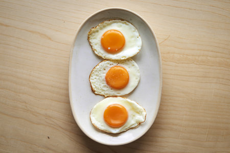 three perfectly cooked sunny-side-up eggsの写真素材