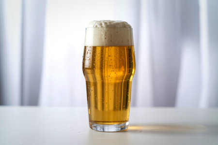 elegant pint glass filled with a refreshing golden beer.の写真素材