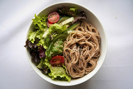 noodles in a bowl with a salad of mixed greensの写真素材