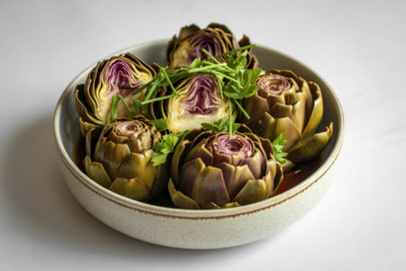 a ceramic bowl filled with glistening braised artichokesの写真素材