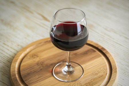 a glass filled with red wine and a bottleの写真素材