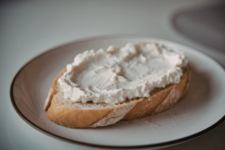 A photo of a bread slice topped with a white cottage cheese spread