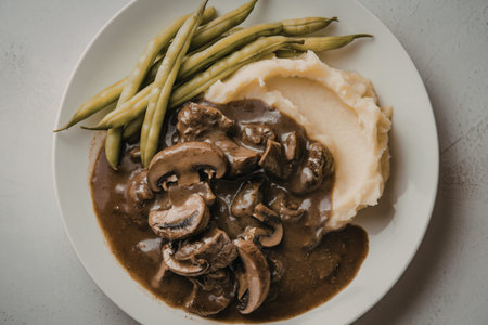 a rich brown gravy with chunks of meat and mushroomsの写真素材