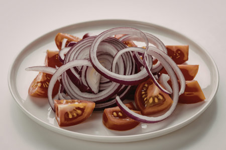 a white ceramic plate containing tomatoes and onionsの写真素材