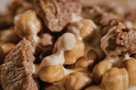 A close-up photograph of golden-brown fried chickpeas with creamy sauceの写真素材