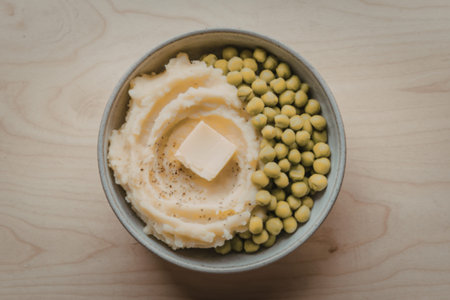 A photo of a bowl containing mashed potatoes and peasの写真素材