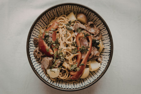 noodles with bell pepper, potatoes, meat, and herbsの写真素材