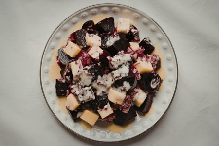 A photo of a plate with a beetroot and diced cheese salad