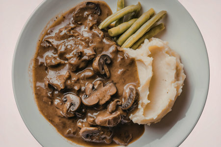 a plate of food containing a rich brown gravy with chunks of meat and mushrooms